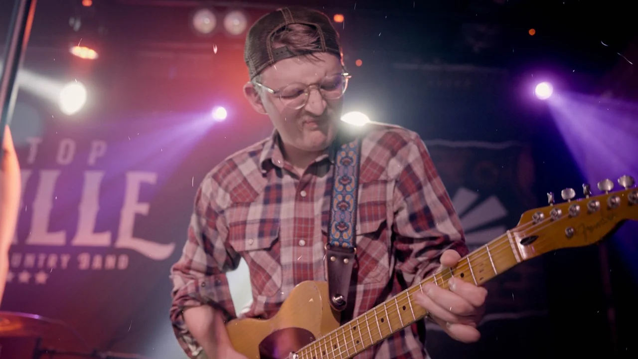 Next Stop Nashville guitarist concentrating during a live set