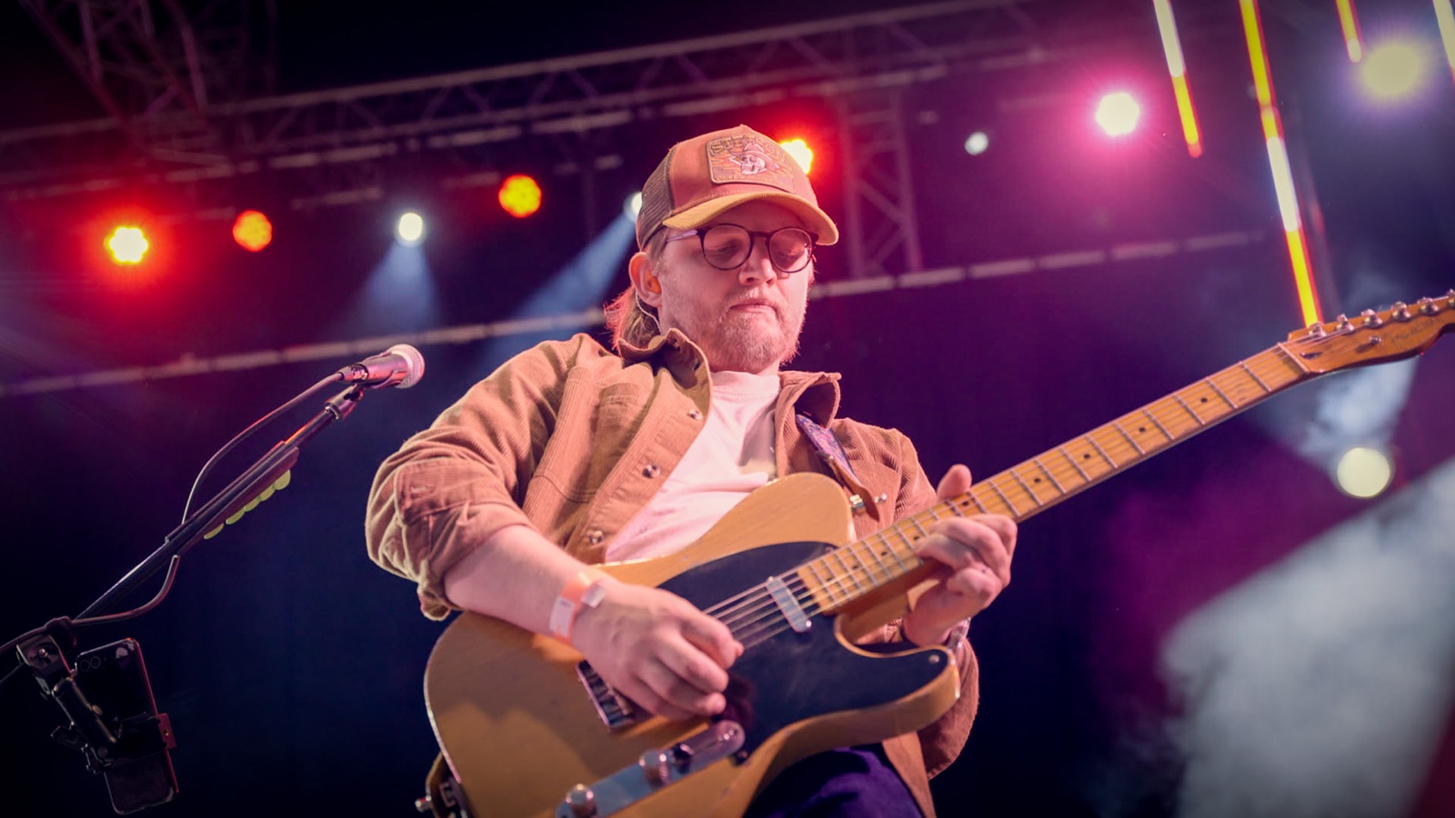 Josh playing electric guitar under festival lights