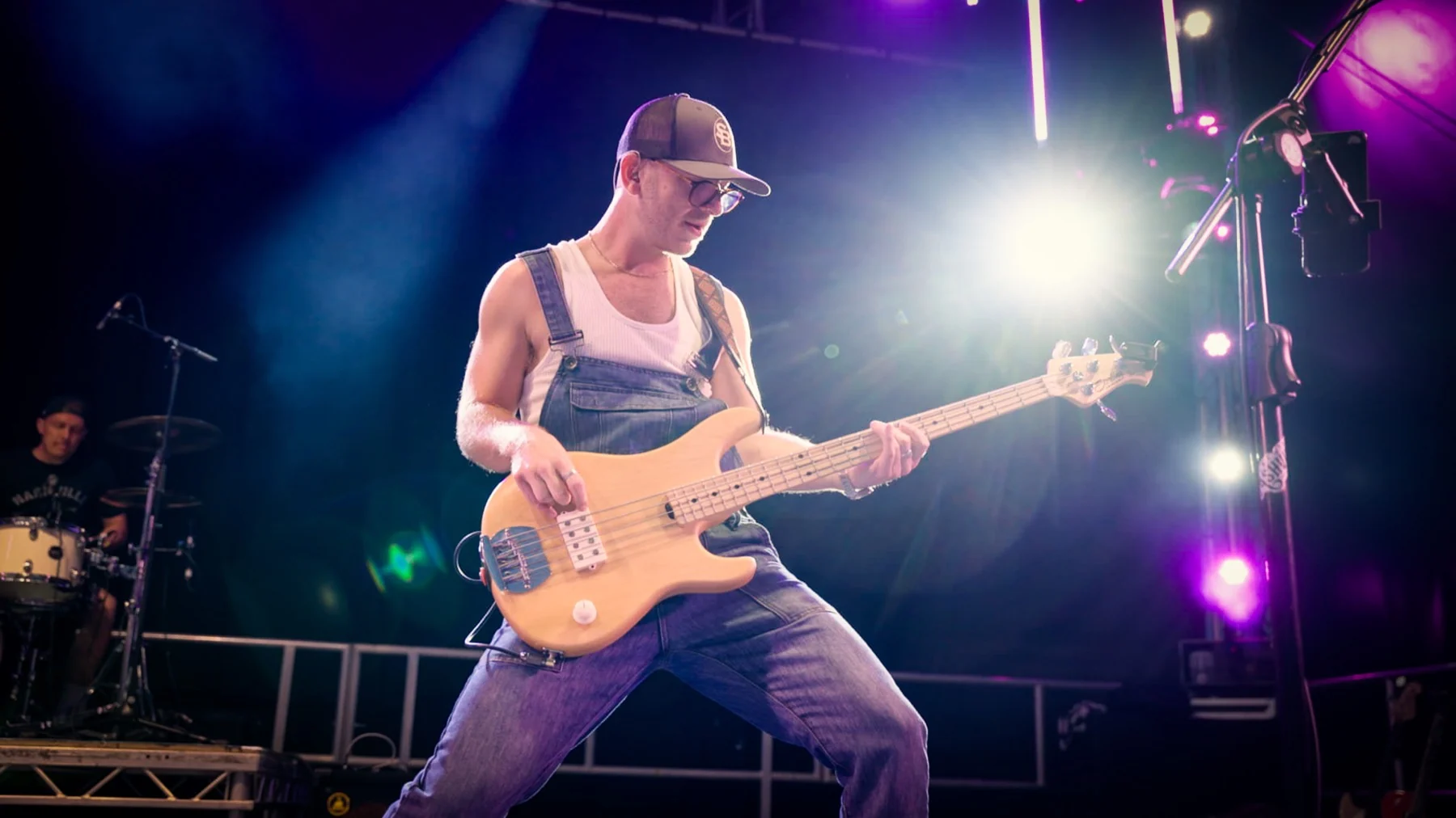 Next Stop Nashville bass player performing on an outdoor festival stage